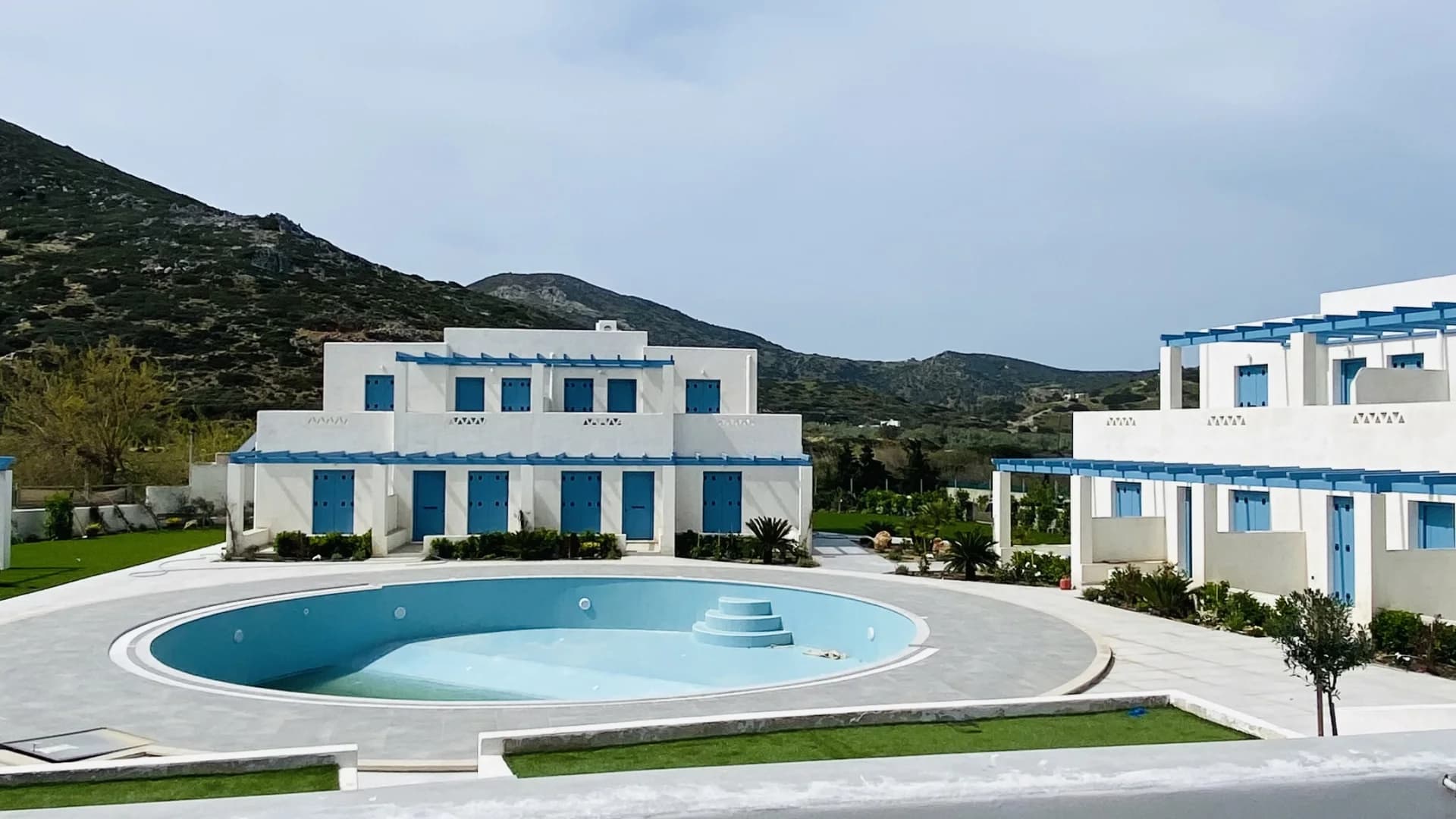 Morfeas Luxury Rooms Complex - Pool and buildings with mountain backdrop